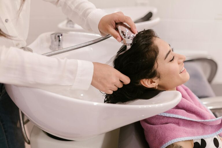 A young woman enjoys a relaxing hair wash at a modern beauty salon.
